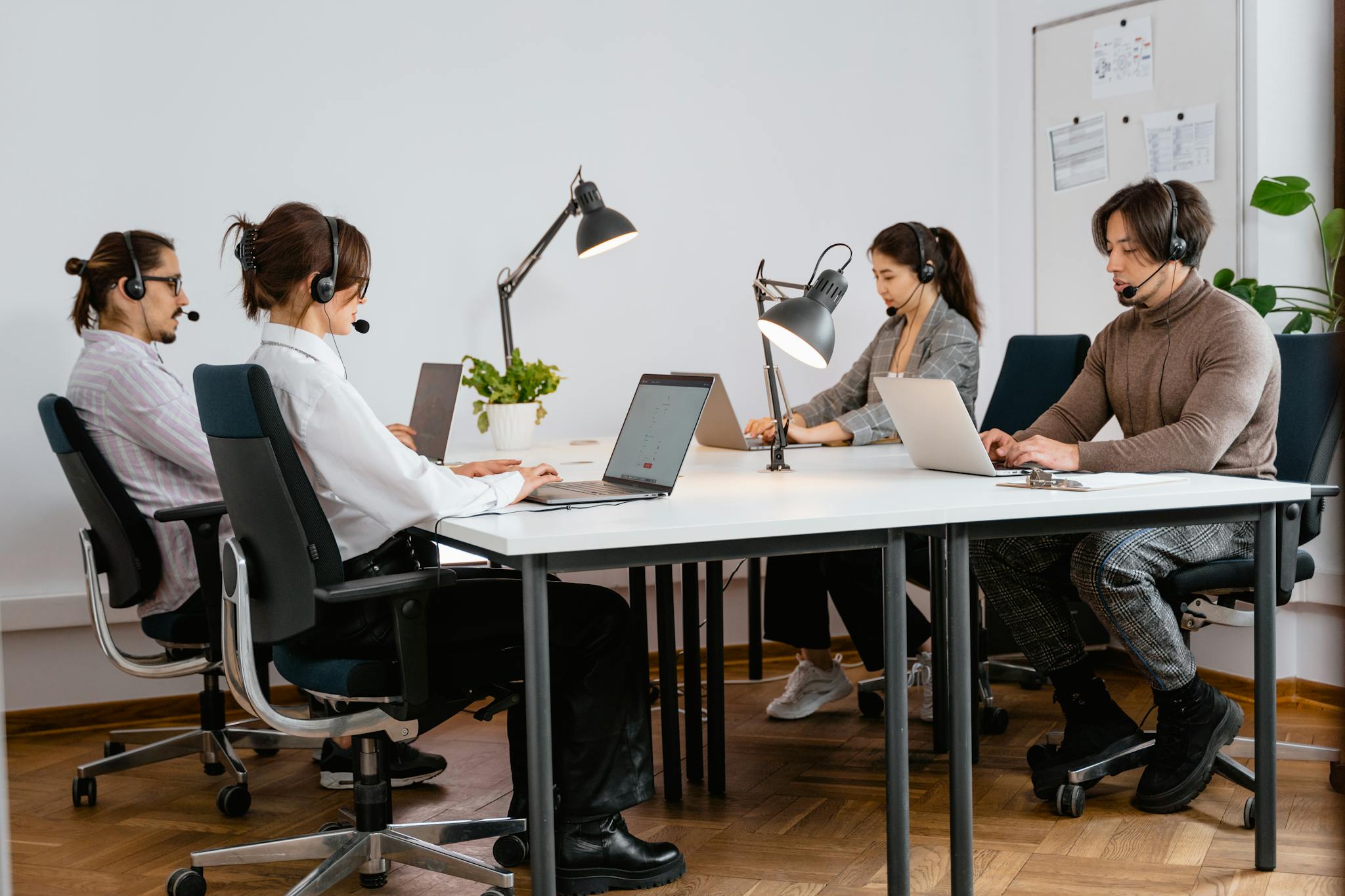 Team of diverse call center agents working diligently in a modern office setting.